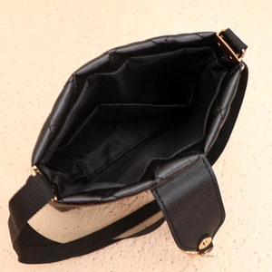 Vue intérieure d'un sac bandoulière matelassé noir avec doublure et fermeture magnétique