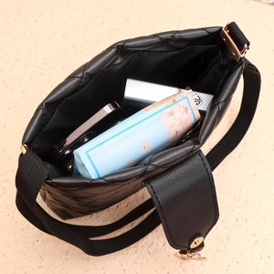 Vue de dessus du sac seau noir matelassé montrant l'intérieur spacieux et les objets