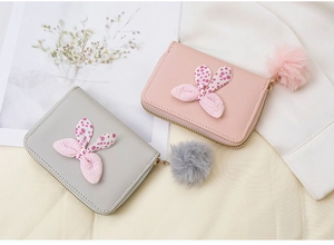 Detail von Mini-Geldbörsen mit Polka-Dot-Schleife und Plüschanhänger in Rosa und Grau