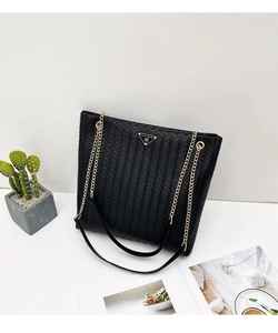 Detalle de bolso tote tejido negro con placa dorada y grabado Luck For You en metal