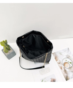 Vista interna del bolso tote tejido negro con bolsillo de cremallera y cadena dorada