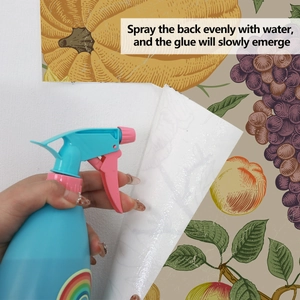 Detail showing water-activated adhesive application on vintage fruit pattern wallpaper