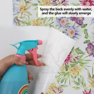 Dimostrazione del retro adesivo attivato dall'acqua sulla carta da parati con fiori