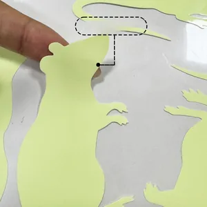 Glow-in-the-dark green mouse wall stickers being peeled off for home decoration