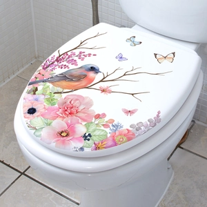 Floral wall sticker with bird and butterfly design on a white toilet lid in a bathroom