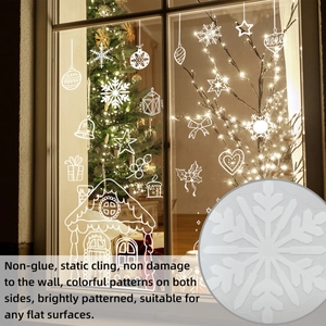 Close-up of white static cling Christmas window decals showing snowflake and gingerbread house