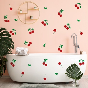 Detail of red cherry wall stickers decorating a pink wall above a minimalist bathtub