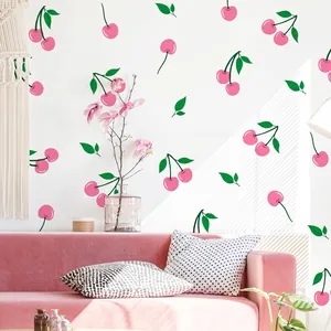 Pink cherry wall decals on white wall with velvet sofa and elegant home decor scene