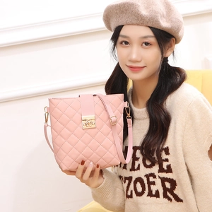 Sac seau matelassé rose avec fermoir doré et bandoulière porté par un mannequin