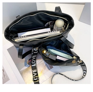 Detailed interior of black quilted tote bag set with wide LOVE printed strap