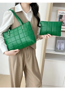 Detail view of a green quilted tote bag set including a matching pouch with metal rivets