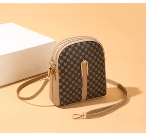 Detailed macro view of the small crossbody bag showing dual zippers and floral monogram