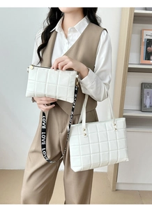 White quilted tote bag set with LOVE print strap shown on a model in a minimalist setting