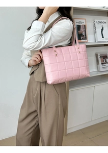 Close-up of pink quilted faux leather tote bag featuring elegant gold square studs