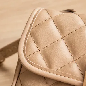 Detailed view of beige crossbody bag showing premium diamond quilted texture and stitching