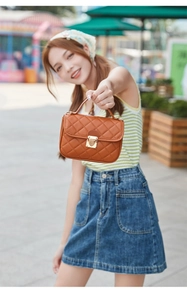 Detailansicht der karamellbraunen Stepptasche mit goldenem Herzverschluss für Damen