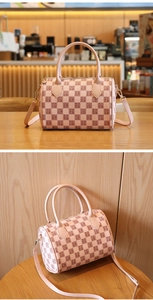 Detailed close-up of pink checkerboard Boston bag with dual handles and wide strap