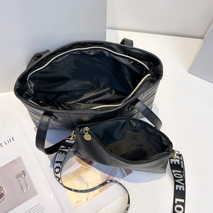 Black quilted tote bag and pouch set with a wide LOVE print shoulder strap in a top view