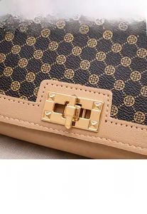 Gros plan sur le motif trèfle et le fermoir doré en métal de ce sac carré pour femme