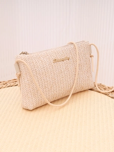 Detailed view of beige woven texture and gold logo on the elegant crossbody chain bag
