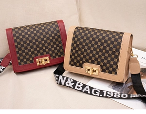 Détail de sacs bandoulière imprimés rouge et beige avec fermoir rotatif doré élégant