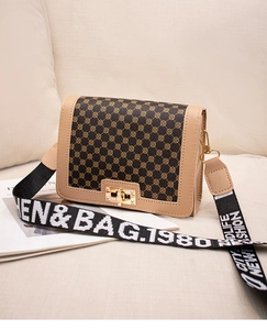 Détail du sac bandoulière vintage avec imprimé floral et fermoir doré rotatif