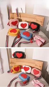 Close-up of heart-pattern crossbody bags in various colors with striped woven straps