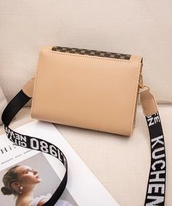 Détail du sac à bandoulière beige avec sangle large à motifs sur fond style de vie
