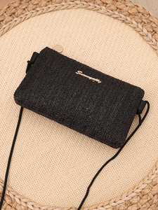 Detail of black woven crossbody bag with V-shaped texture and golden metal logo