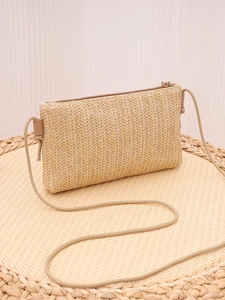 Detail of bohemian straw crossbody bag showing herringbone weave texture and zipper
