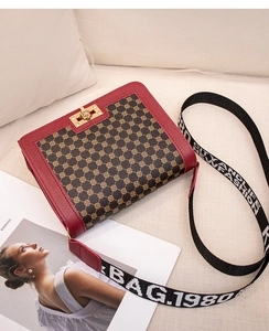 Détail du sac bandoulière carré rouge avec imprimé floral et fermoir en métal doré