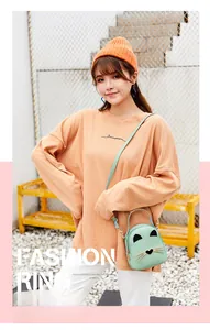 Detail of mint green cat-shaped crossbody bag with ears and whiskers in a lifestyle shot