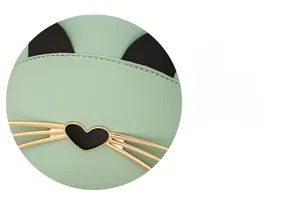 Close-up of mint green leather backpack featuring gold cat whiskers and heart detail