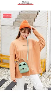 Mint green cat mini bag shown as a crossbody with adjustable strap in outdoor setting