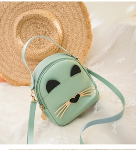 Close-up of mint green cat-themed mini bag with 3D ears and metal whiskers on lace