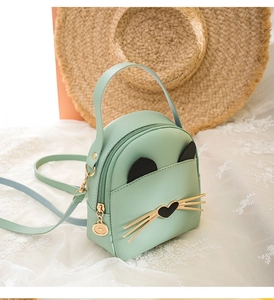 Close-up of mint green mini backpack with cat ear design and heart-shaped nose feature