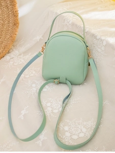 Detail of mint green PU leather mini backpack showing golden zipper and lace texture