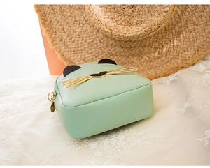 Detail of light green cat-shaped mini crossbody bag with gold heart hardware and ears