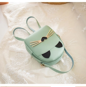Close-up of mint green cat-themed mini backpack with gold whiskers and faux leather texture
