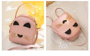 Detailed view of a pink kitty-themed mini backpack with cute cat ears and golden whiskers