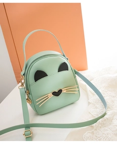 Detail of mint green cat-shaped mini bag featuring metallic whiskers and heart nose