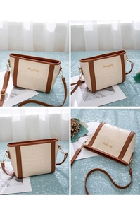 Detailaufnahmen der beigen Beuteltasche mit braunem Besatz und Krokoprägung
