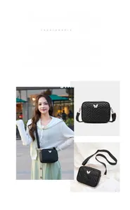 Detail of black crossbody bag featuring geometric stitching and gold butterfly metal buckle