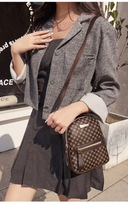 Outdoor-Streetstyle mit einem kleinen braunen Rucksack mit goldenem geometrischem Muster