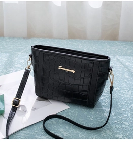 Detail der schwarzen Bucket Bag aus Kunstleder mit Krokostruktur und Goldlogo