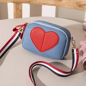 Litchi texture sky blue crossbody bag with large red heart and striped strap