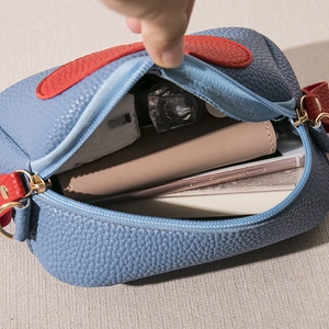 Litchi pattern leather crossbody bag in blue and red showing spacious interior storage
