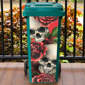 Dunkles Totenkopf und rote Rosen Aufkleber auf einem grünen Outdoor-Mülleimer mit Rollen