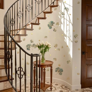 Golden and dark green ginkgo leaf wall decals decorating a white wall near a wooden staircase