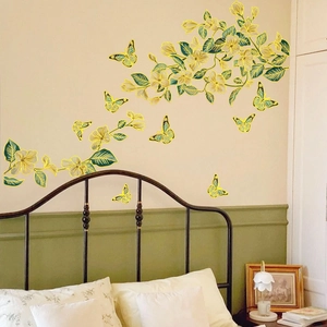 Detail view of floral wall decals with gold outlines and butterfly accents on bedroom wall